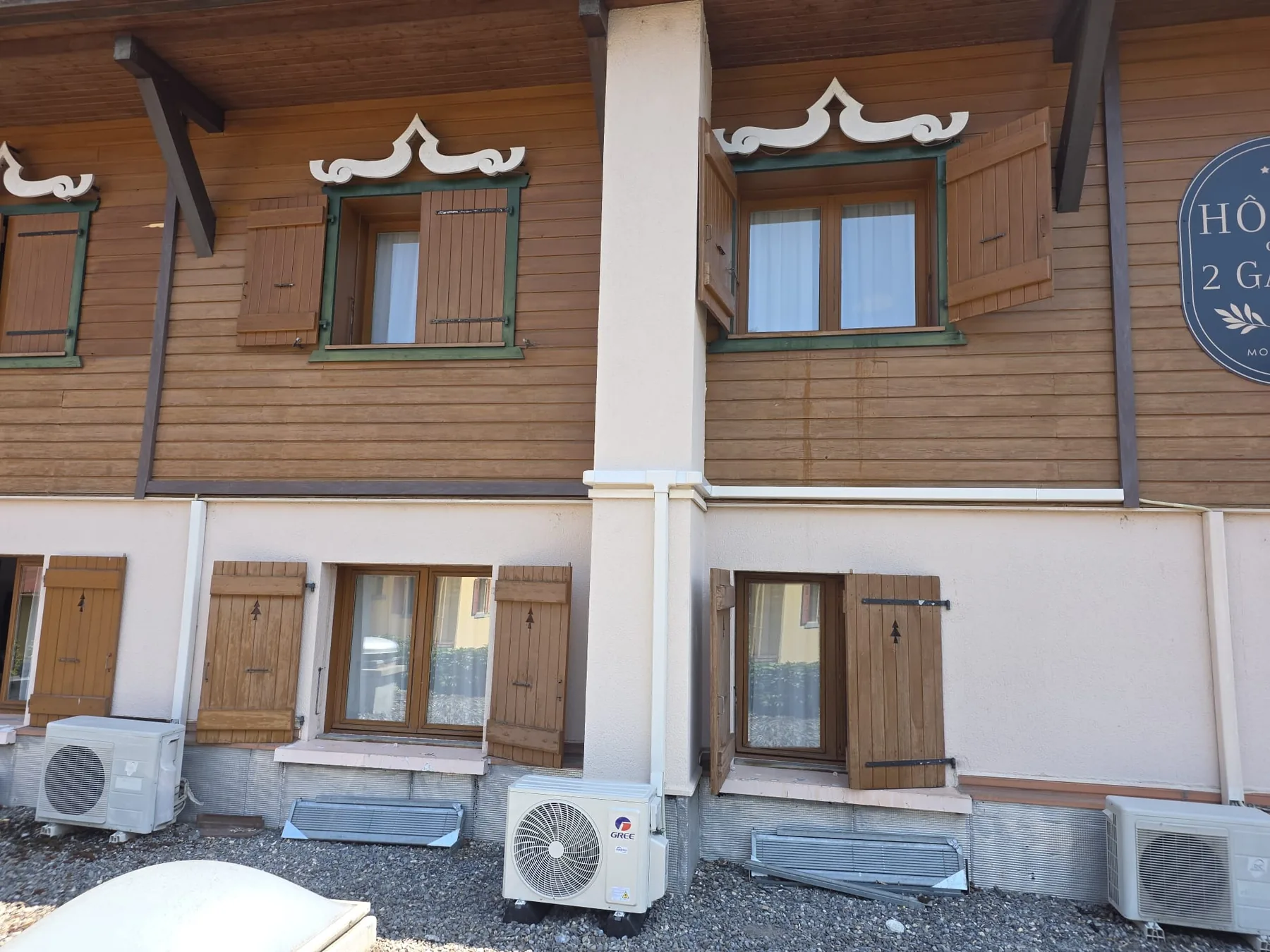 Unités extérieures de climatisation au pied d'un hôtel-chalet