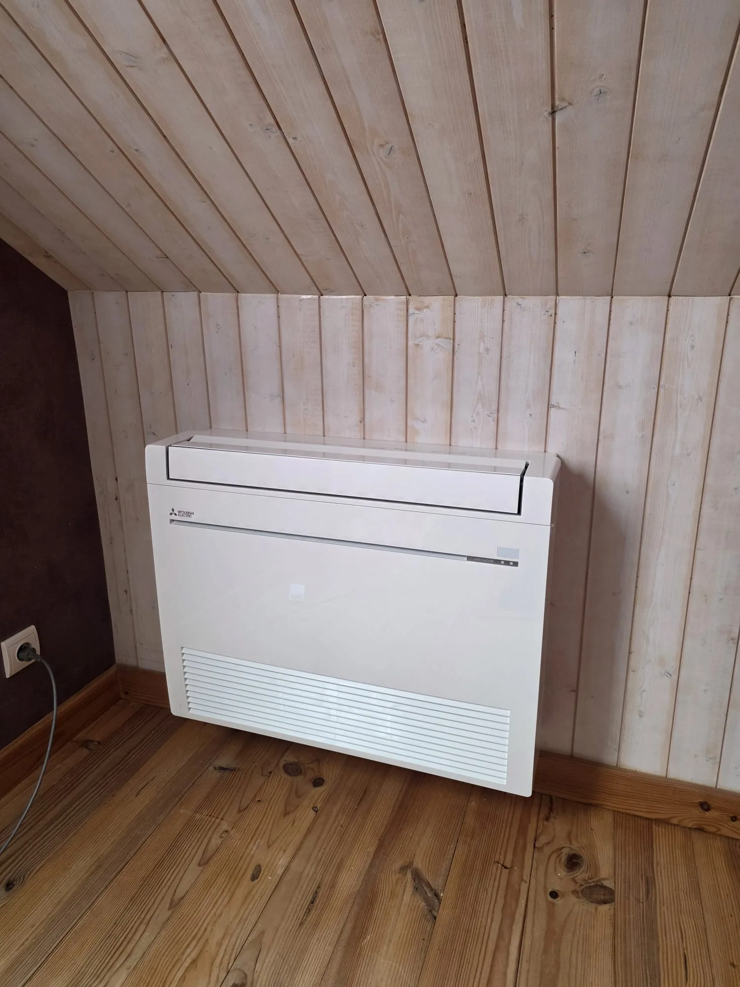 Console de climatisation sous une pente lambrissée